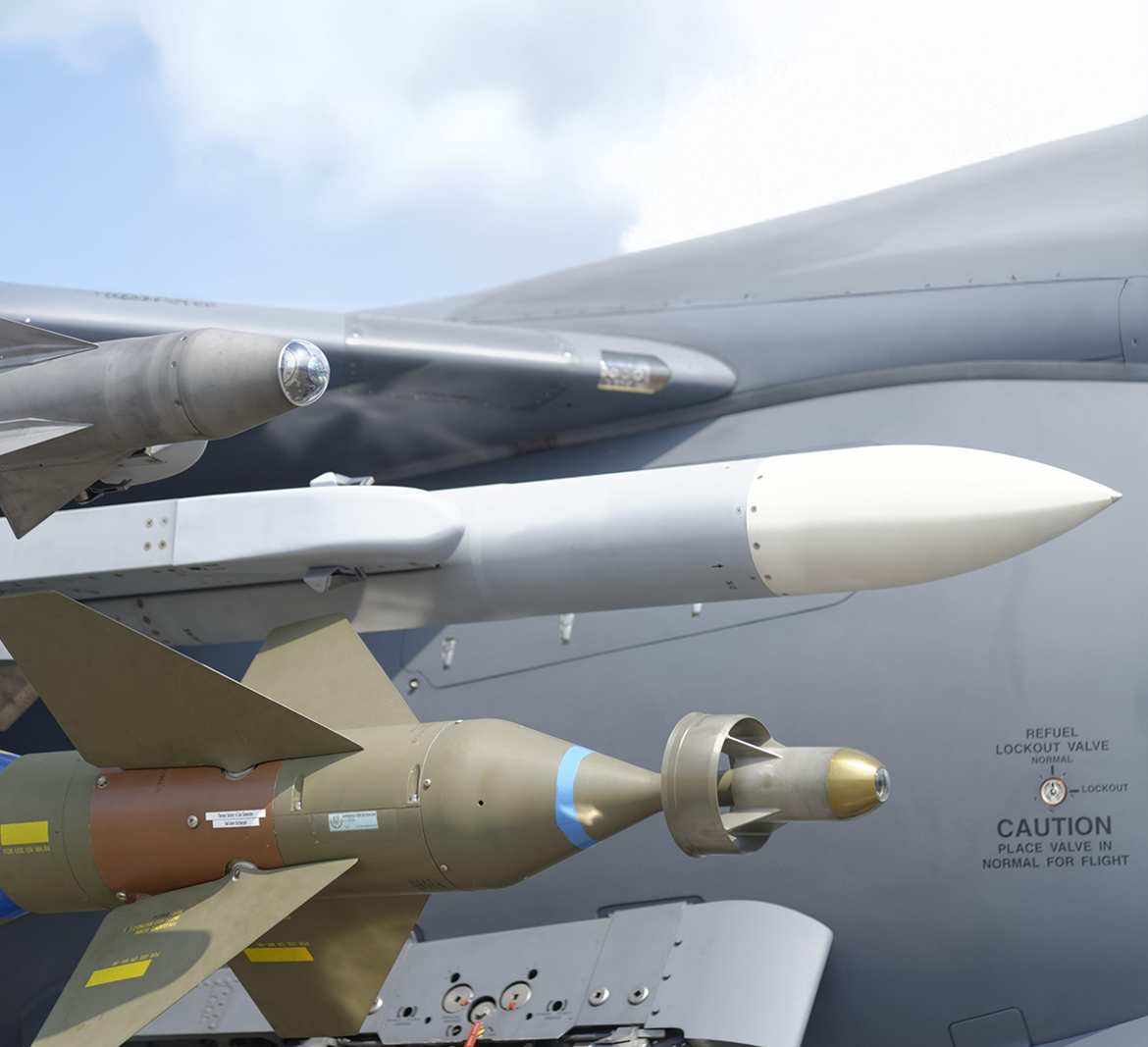 An array of ordnance is depicted under the wing of an aircraft.